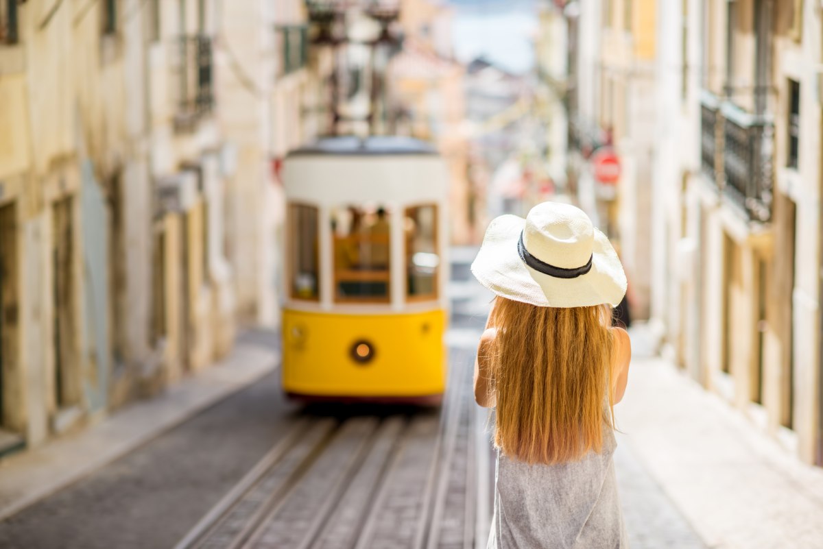 Woman making a photo of Lisbon tram © iStock