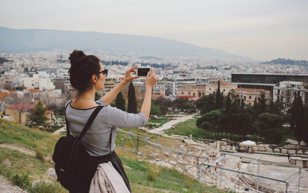 A woman photographing one of the Athenian hills © iStock