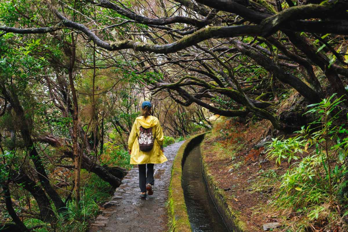 Woman walking along a levada, Madeira © iStock